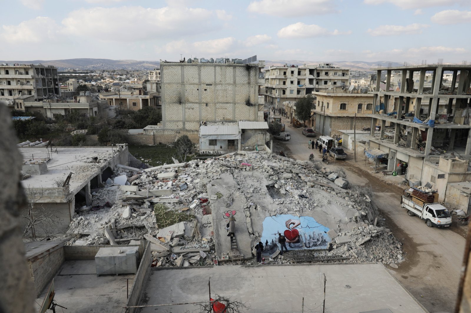 Syrian artists Aziz Asmar and Salam Hamed paint street art on the rubble of damaged buildings in the aftermath of a deadly earthquake, in the opposition-held town of Jandaris, Syria Feb. 22, 2023. (Reuters Photo)