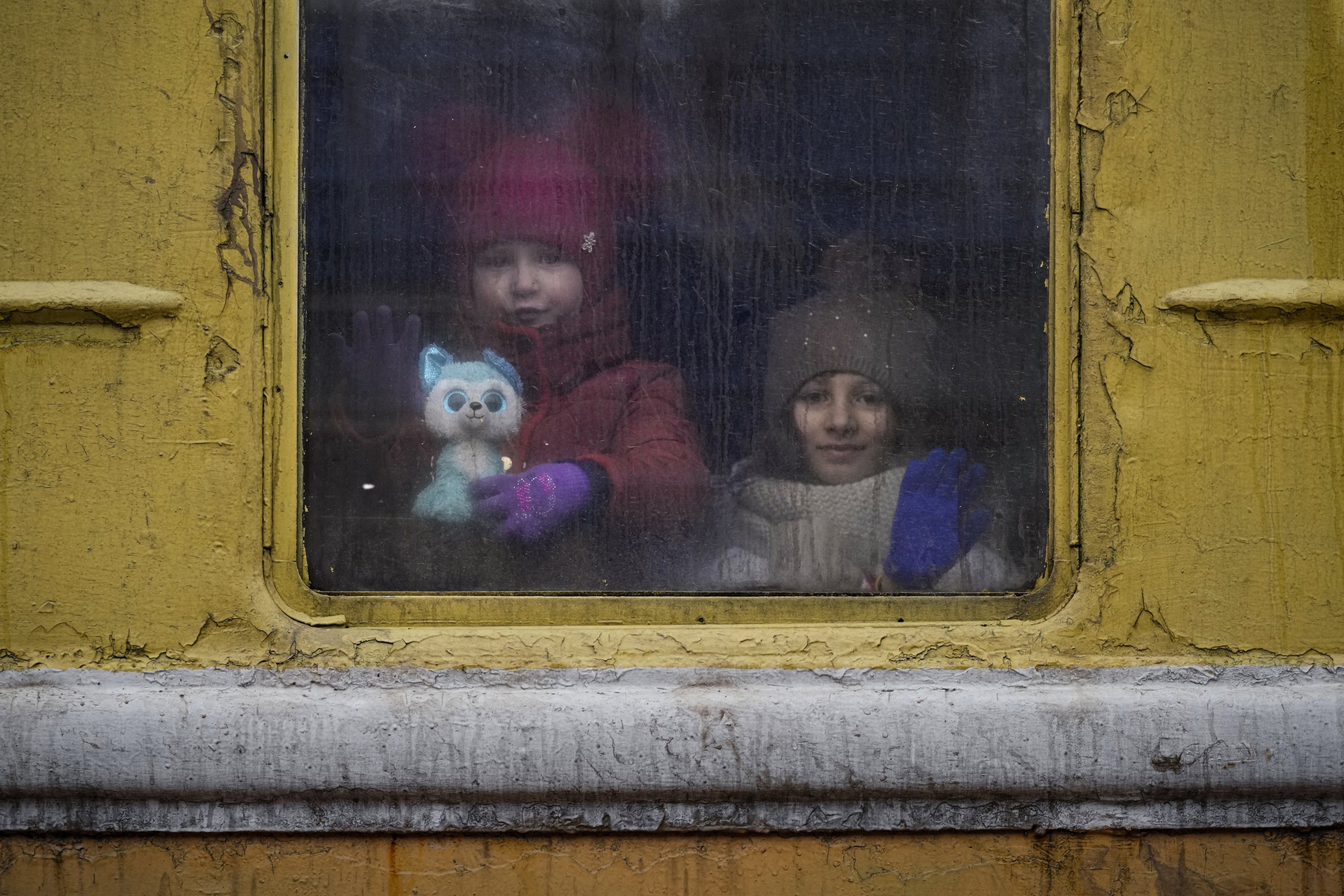 Anak-anak melihat keluar jendela kereta menuju Lviv yang tidak dipanaskan, di Kyiv, Ukraina, 3 Maret 2022. (Foto AP)