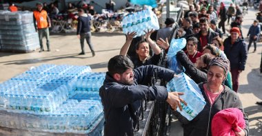 People receive crates of water in the aftermath of powerful earthquakes in the Samandağ district of Hatay, Türkiye, Feb. 23, 2023. (EPA Photo)