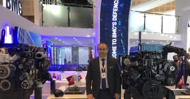 Mustafa Kaval, the general manager of BMC Power, poses in front of the company's engines on display at the IDEX fair in Abu Dhabi, UAE, Feb. 24, 2023. (AA Photo)