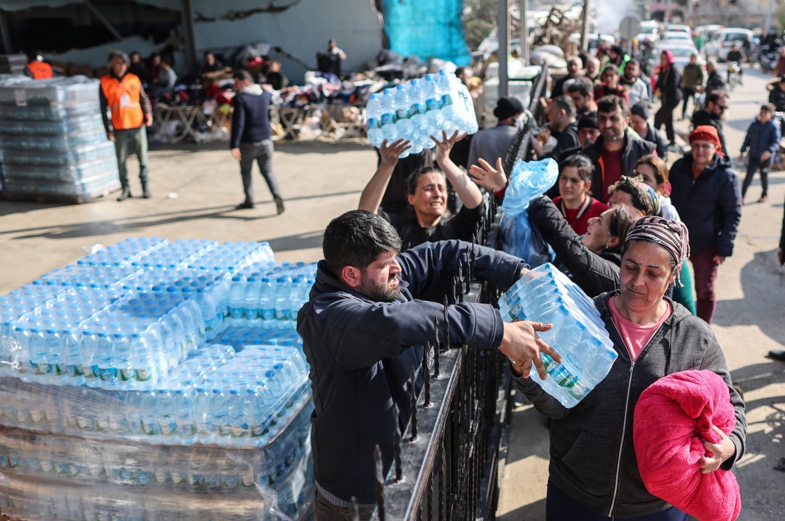 People receive crates of water in the aftermath of powerful earthquakes in the Samandağ district of Hatay, Türkiye, Feb. 23, 2023. (EPA Photo)