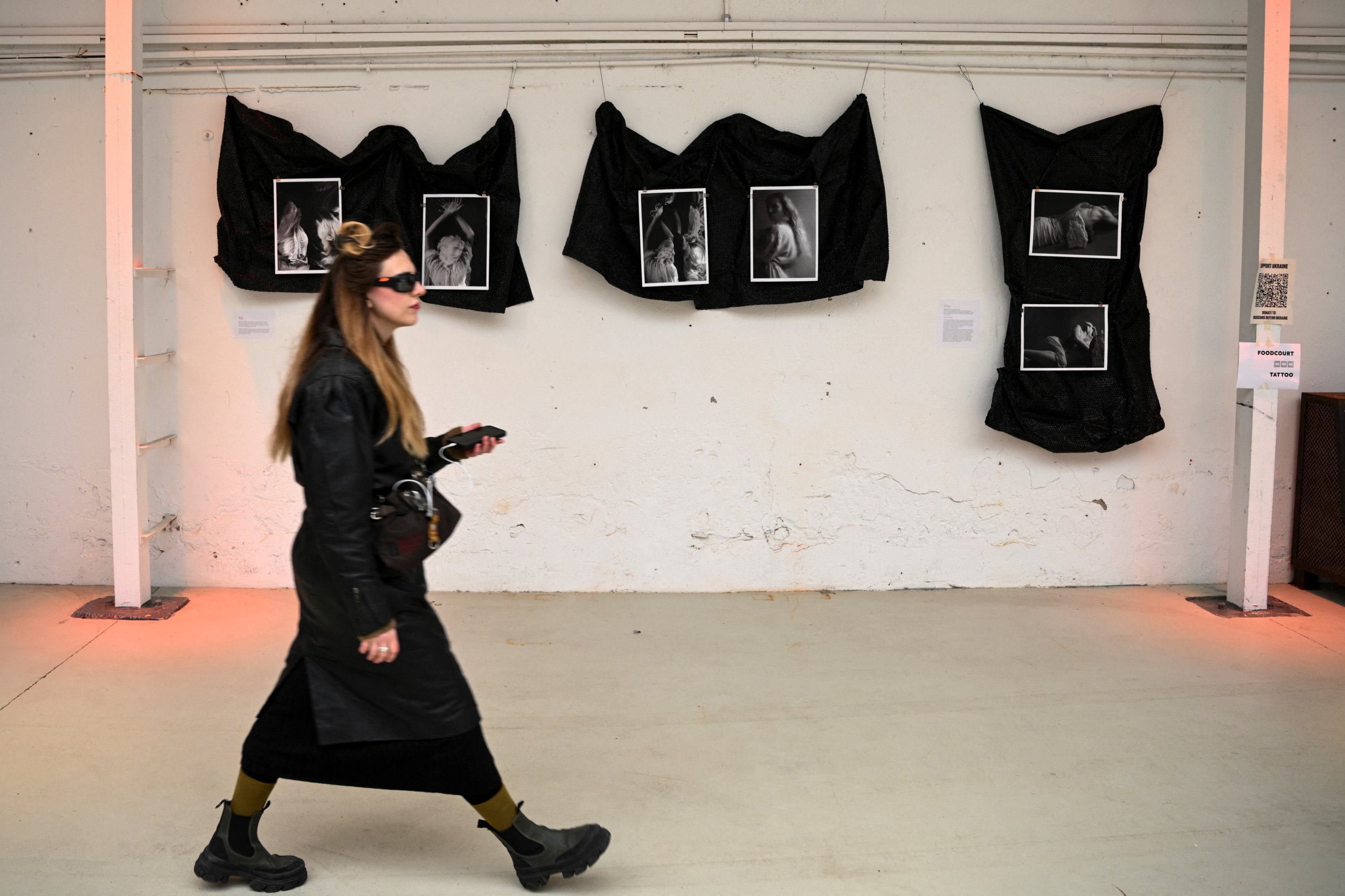 Seorang wanita berjalan melewati sebuah karya seni di Art Weapon Festival yang dibuat selama invasi Rusia ke Ukraina di 