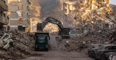 A digger removes the rubble of collapsed buildings following the deadly earthquakes in Antakya, Hatay province, southern Türkiye, Feb. 20, 2023. (AFP Photo)