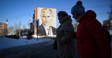 Pedestrians walk past a mural of Russian President Vladimir Putin on a residential building in the town of Kashira, Moscow, Russia, Feb. 23, 2023. (AFP Photo)