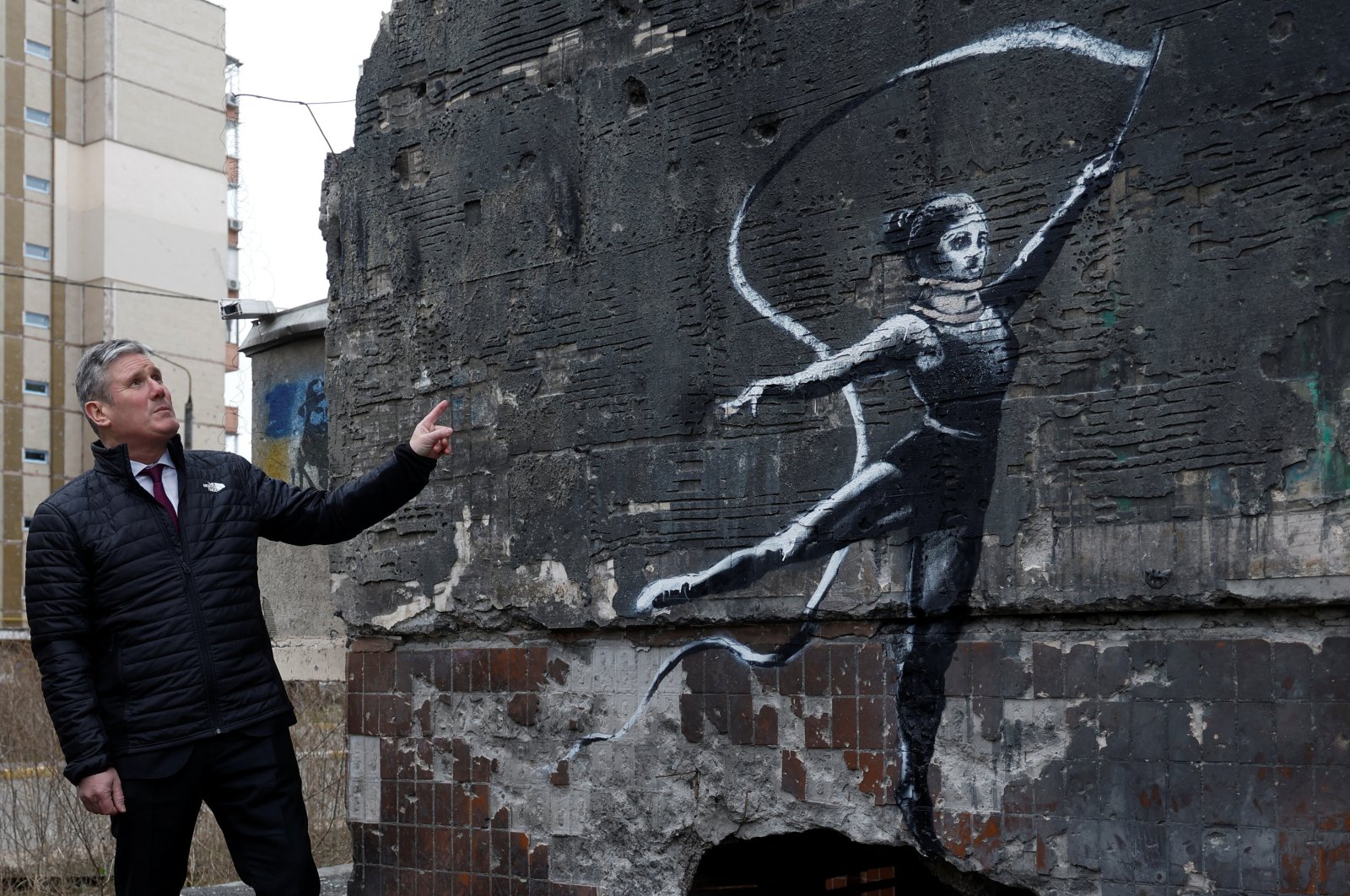 British Labour Party leader Keir Starmer next to a heavily damaged residential building with the work of world-renowned graffiti artist Banksy in the town of Irpin, Ukraine, Feb. 16, 2023. (Reuters Photo)