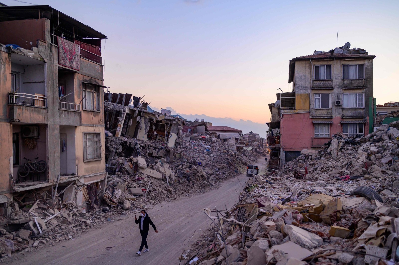 A man walks past collapsed buildings in Antakya, Türkiye, Feb. 20, 2023. (AFP Photo)