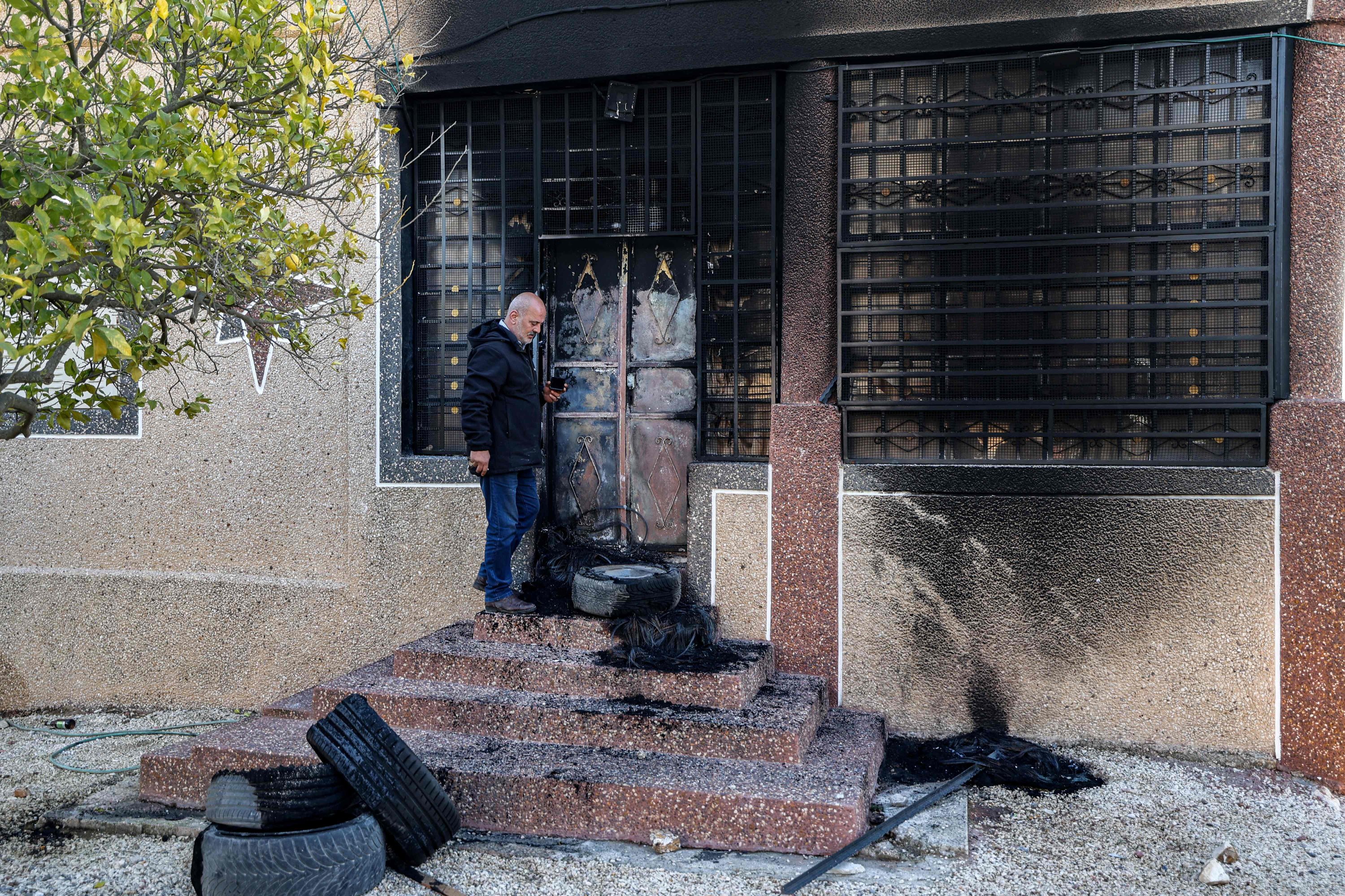 A man stands outside a damaged building after Israeli settlers attacked villages near Nablus, occupied West Bank, Feb. 27, 2023. (EPA Photo)