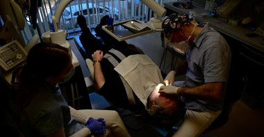 Hungarian dentist Ivan Solymosi checks British patient Bob Martin&#039;s implants at the Kreativ Dental Clinic in Budapest, Hungary, Feb. 10, 2023. (Reuters Photo)