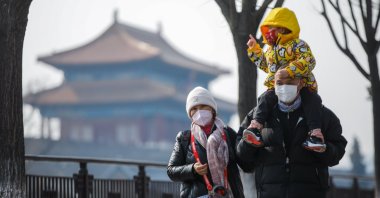Tourists wearing face masks walk near the Turret of the Palace Museum in Beijing, China, Feb. 22, 2023. (EPA Photo)