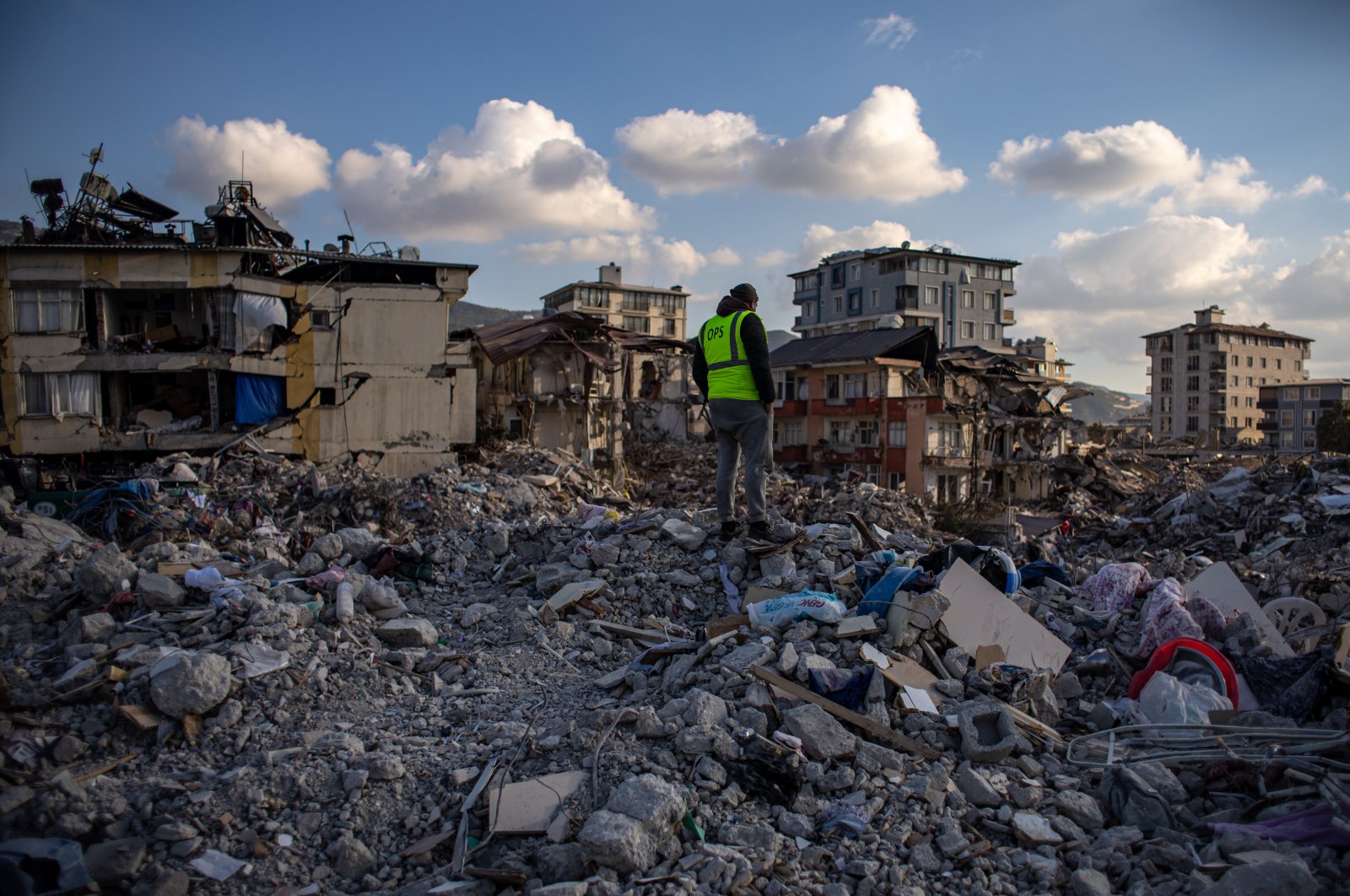A worker looks on debris of collapsed buildings after a powerful earthquake, in Hatay, Türkiye, Feb. 19, 2023. (EPA Photo)