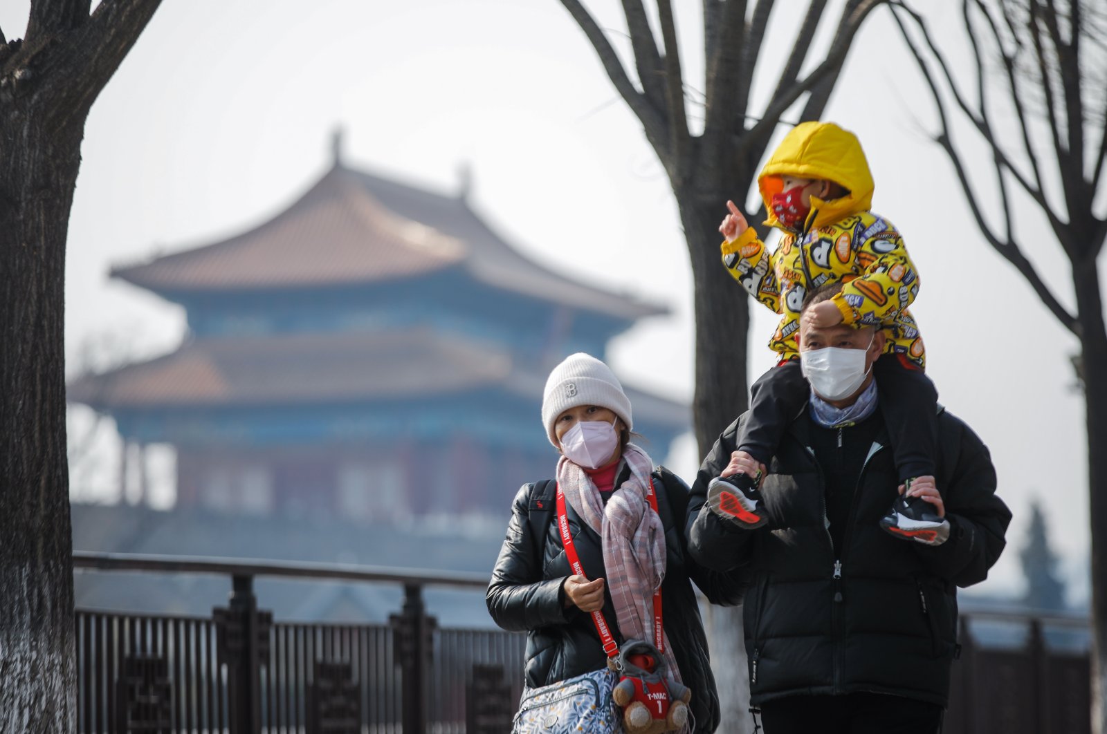 Tourists wearing face masks walk near the Turret of the Palace Museum in Beijing, China, Feb. 22, 2023. (EPA Photo)