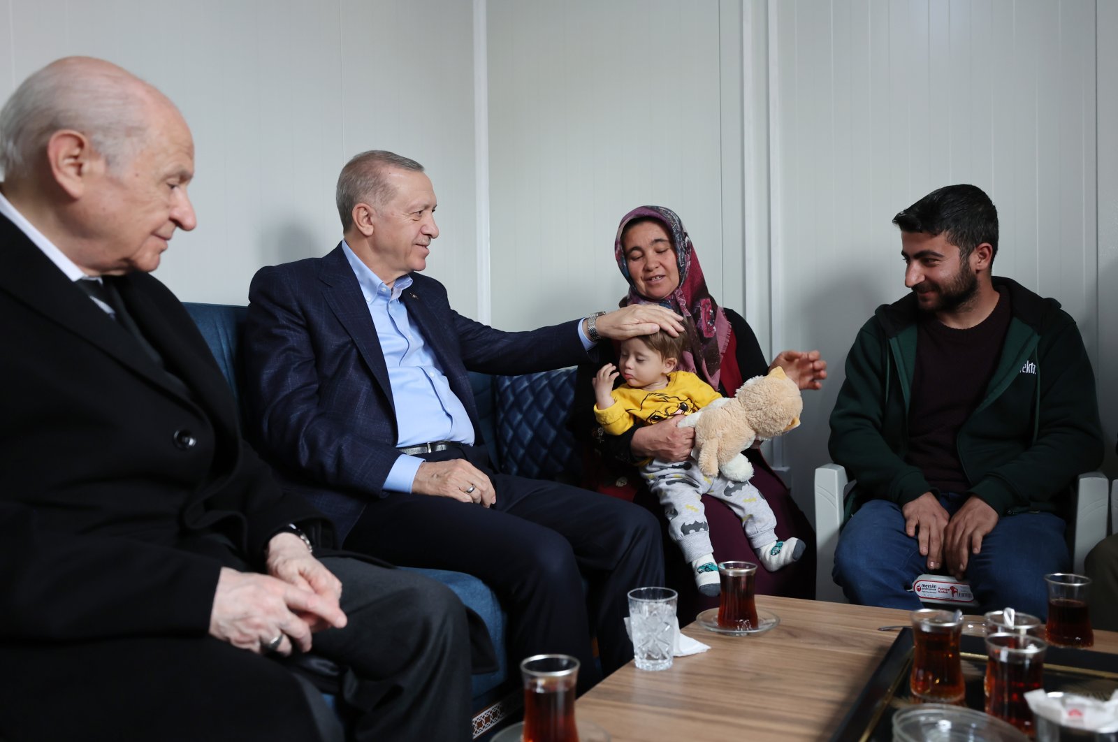 President Recep Tayyip Erdoğan (2nd L), accompanied by MHP leader Devlet Bahçeli (L), visits a family of quake victims, in Adıyaman, southeastern Türkiye, Feb. 27, 2023. (AA Photo)
