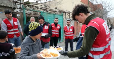 The team of Red Crescent volunteers consisting of international students from different countries distribute food to children in quake-hit Kahramanmaraş, southeastern Türkiye, Feb. 26, 2023. (AA Photo)