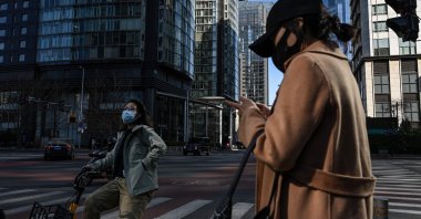 People commute at the central business district in Beijing, China, March 1, 2023. (AFP Photo)