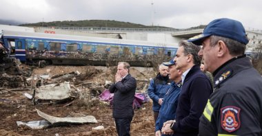 Greek transport minister, Kostas Karamanls (Center) reacting as he visits a crash site with Greek Prime Minister Kyriakos Mitsotakis (Second right) following the deadly train accident where at least 38 people died and another 85 were injured near the Greek city of Larissa. March 1, 2023. (AFP Photo)