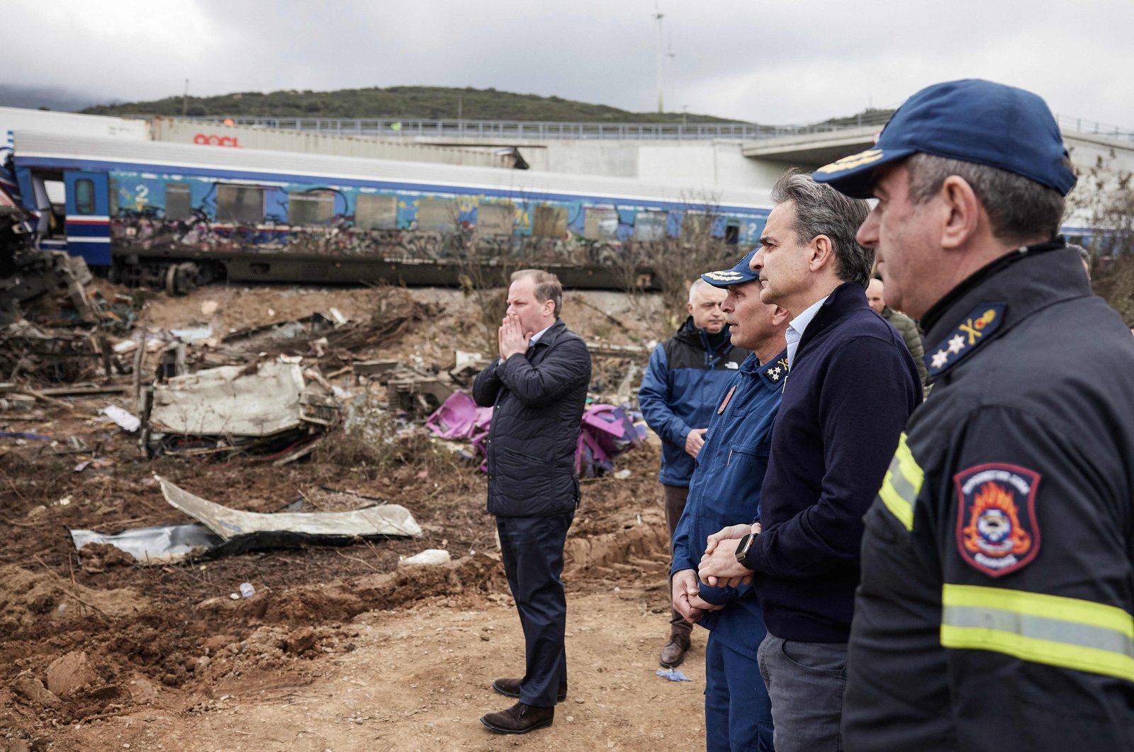 Greek transport minister, Kostas Karamanls (Center) reacting as he visits a crash site with Greek Prime Minister Kyriakos Mitsotakis (Second right) following the deadly train accident where at least 38 people died and another 85 were injured near the Greek city of Larissa. March 1, 2023. (AFP Photo)