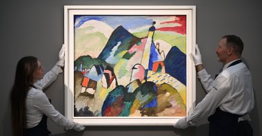 Employees poses with an artwork entitled &#039;Murnau mi Kirche II&#039; (Murnau with Church II) by Wassily Kandinsky, during a photocall at Sotheby&#039;s auction house in central London, U.K., Feb. 22, 2023. (AFP Photo) 