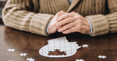 Senior man playing with puzzles on a table, in this undated file photo. (Shutterstock File Photo)