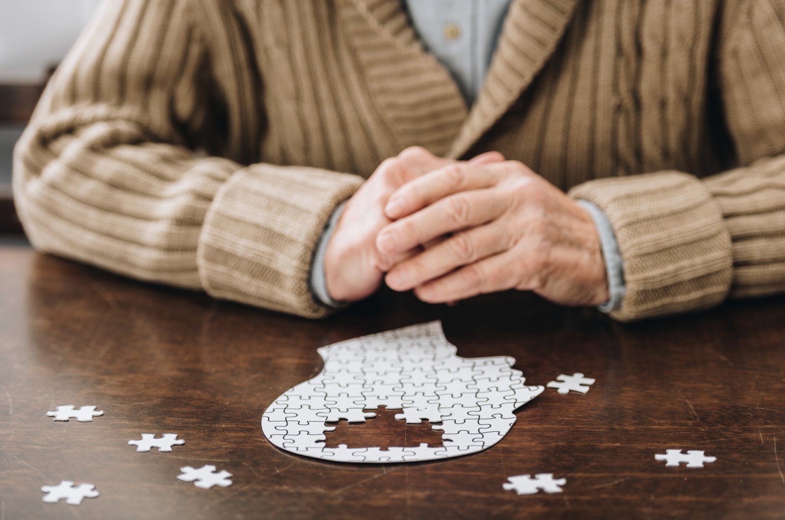 Senior man playing with puzzles on a table, in this undated file photo. (Shutterstock File Photo)