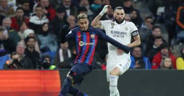 Barcelona's Brazilian forward Raphinha (L) vies with Real Madrid's French forward Karim Benzema during the Copa del Rey (King's Cup) semifinal first leg football match at the Santiago Bernabeu stadium, Madrid, Spain, March 2, 2023. (AFP Photo)