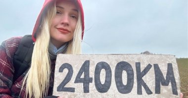 Franziska Niehus with a cardboard sign displaying "2,400 kilometers," the distance she is determined to walk from Austria to Türkiye. (AA File Photo)