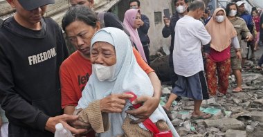 A woman weeps at a neighborhood affected by a fuel depot fire in Jakarta, Indonesia, March 4, 2023. (AP Photo)