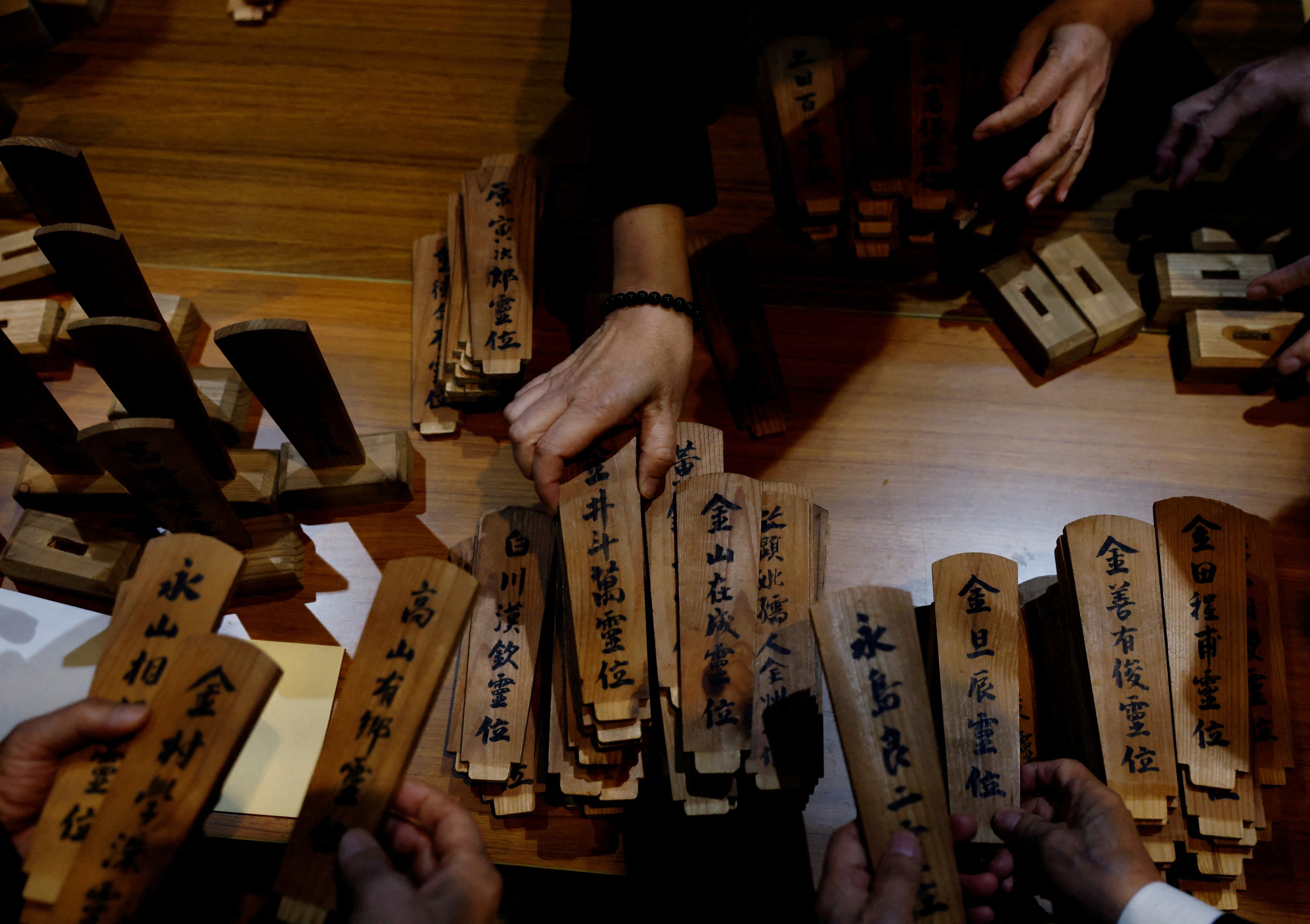 Kerabat pekerja Korea Selatan yang tewas dalam bencana di tambang batu bara Chosei, memilah tablet leluhur untuk para korban di sebuah kuil di Ube, Jepang, 4 Februari 2023. (Foto Reuters)