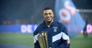 Kylian Mbappe poses with a trophy at the end of a ceremony after he became Paris Saint-Germain's all-time top scorer with his 201st goal for the club in their 4-2 win in the French L1 football match against FC Nantes at The Parc des Princes Stadium, Paris, France, March 4, 2023. (AFP Photo)