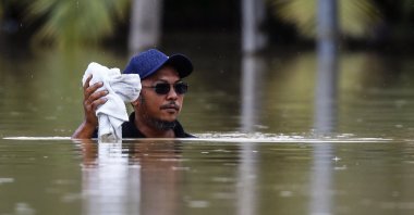 A man wades through a flooded area while raining in Yong Peng, Johor, Malaysia, March 4, 2023. (EPA Photo)