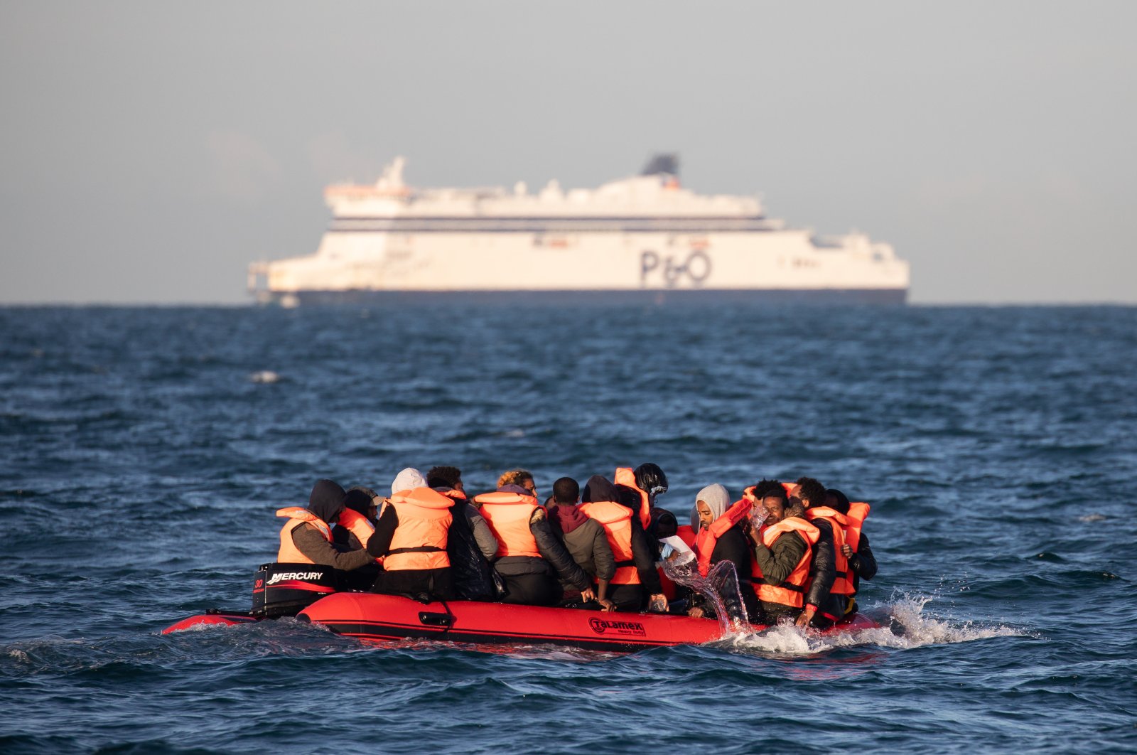 Migrants packed tightly onto a small inflatable boat bail water out as they attempt to cross the English Channel, Dover, U.K., Sept. 7, 2020. (Getty Images)
