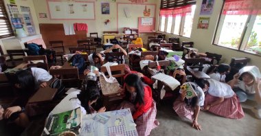 Students taking shelter inside their classroom after a 6.0-magnitude earthquake hit Mati, southern Philippines, March 7, 2023. (AFP Photo)