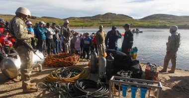 People gather at the site where rescue teams attempted to recover the bodies of five Peruvian soldiers that drowned in the river Ilave, Ilave, Peru, March 6, 2023. (AFP Photo)