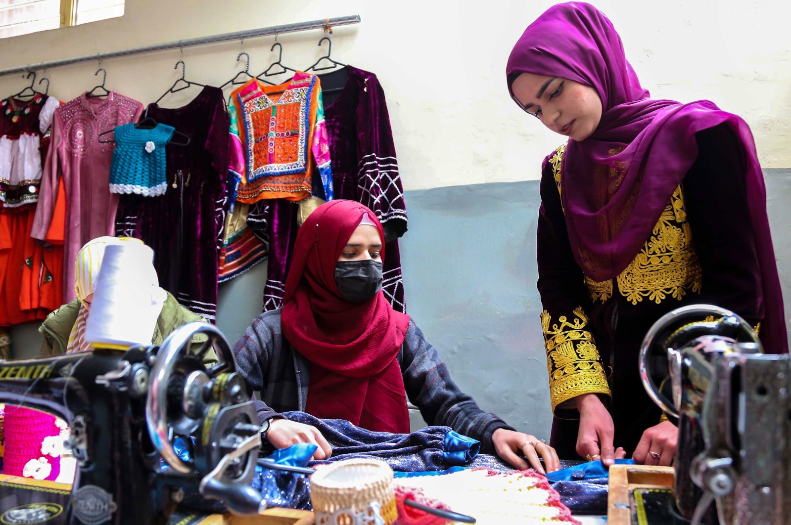 Husna Raoufi (R), a former student of Journalism at Kabul University, works at her tailoring workshop in Kabul, Afghanistan, Feb. 8, 2023. (EPA Photo)