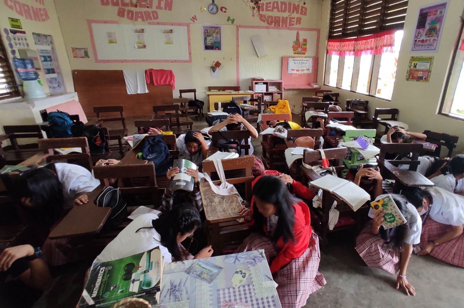 Students taking shelter inside their classroom after a 6.0-magnitude earthquake hit Mati, southern Philippines, March 7, 2023. (AFP Photo)