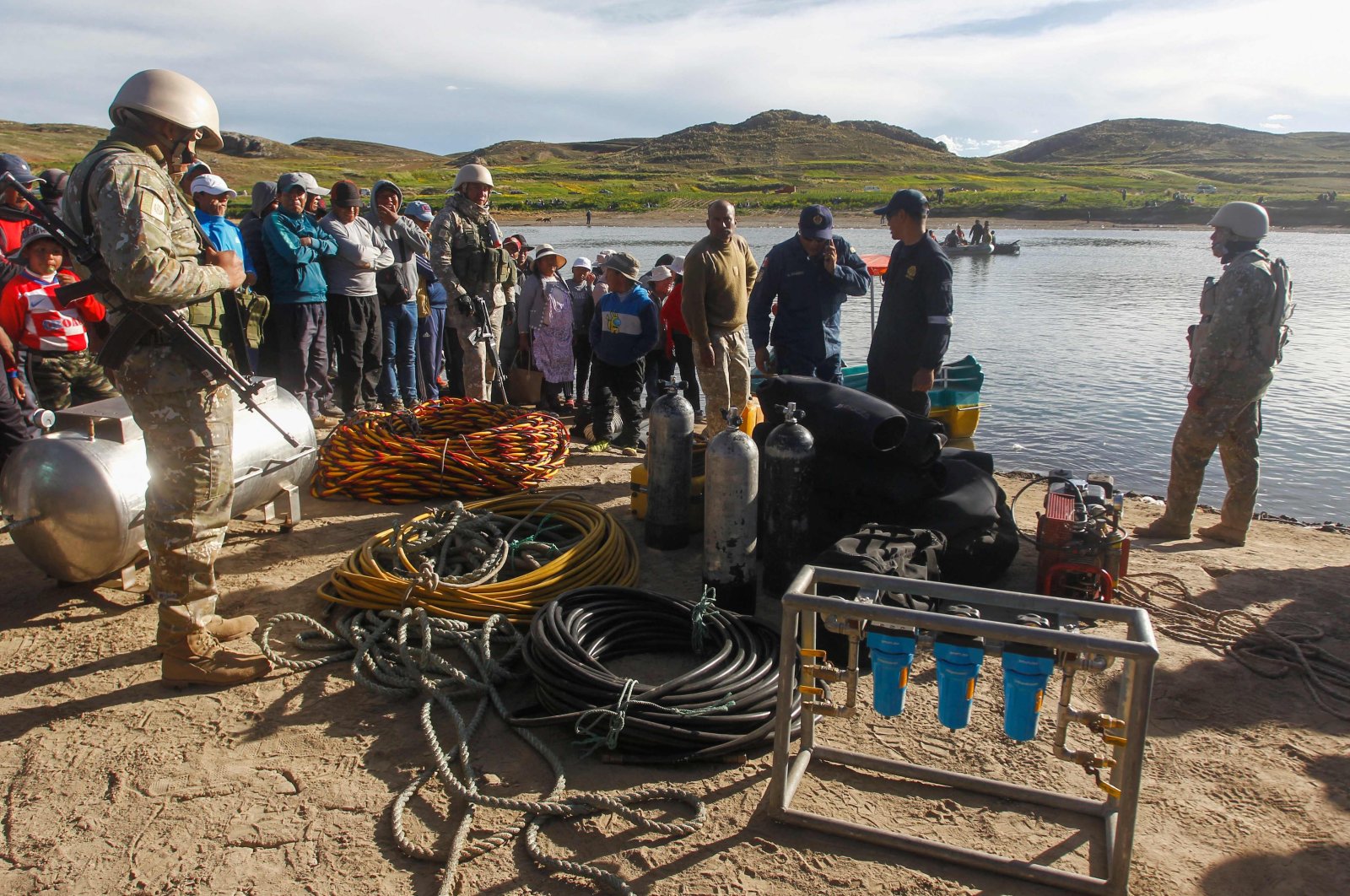 People gather at the site where rescue teams attempted to recover the bodies of five Peruvian soldiers that drowned in the river Ilave, Ilave, Peru, March 6, 2023. (AFP Photo)