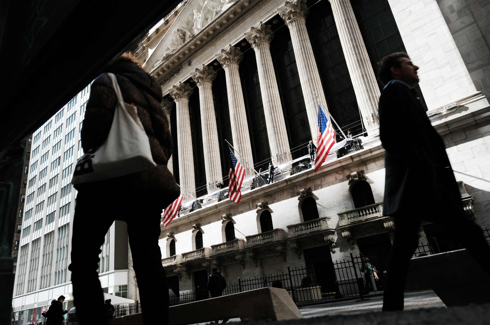 People walk by the New York Stock Exchange (NYSE) in the Financial District on March 7, 2023. (Getty Images via AFP)