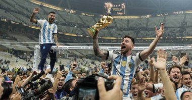 Argentina&#039;s Lionel Messi celebrates with the trophy in front of fans after winning the World Cup final soccer match between Argentina and France at the Lusail Stadium in Lusail, Qatar, Dec. 18, 2022. (AP Photo)