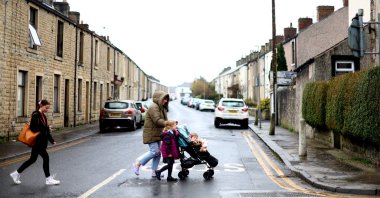 Louise Sharples, 35, with her daughters, Lola, 4 and Sunnie, 1, walk along a residential street in Clitheroe, East Lancashire, Britain, March 1, 2023. (Reuters Photo)
