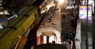 A crane is deployed to lift a derailed train at the scene of a railroad accident in the city of Qalyub in Qalyub province, Egypt, March 7, 2023. (AFP Photo)