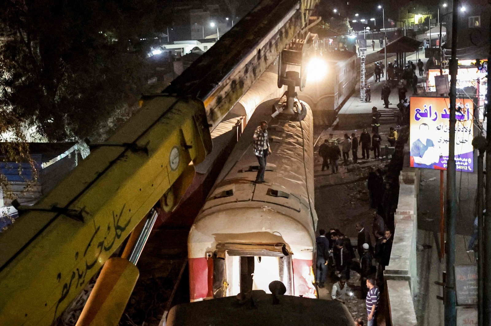 A crane is deployed to lift a derailed train at the scene of a railroad accident in the city of Qalyub in Qalyub province, Egypt, March 7, 2023. (AFP Photo)