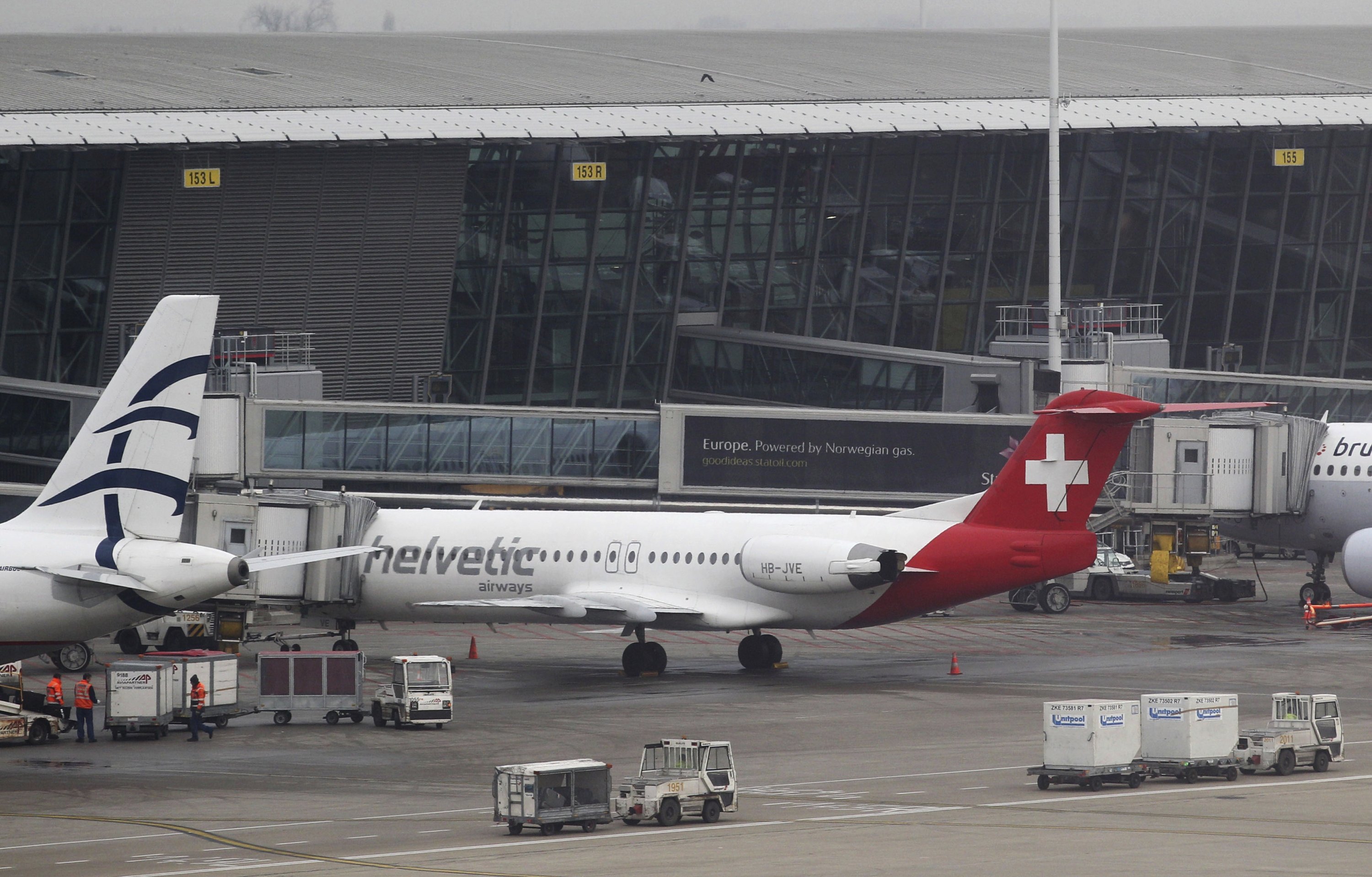 Gerobak bagasi melewati pesawat Helvetic Airways tempat berlian senilai sekitar $50 juta dicuri di landasan bandara internasional Brussels, Brussels, Belgia, 19 Februari 2013. (Foto AP)