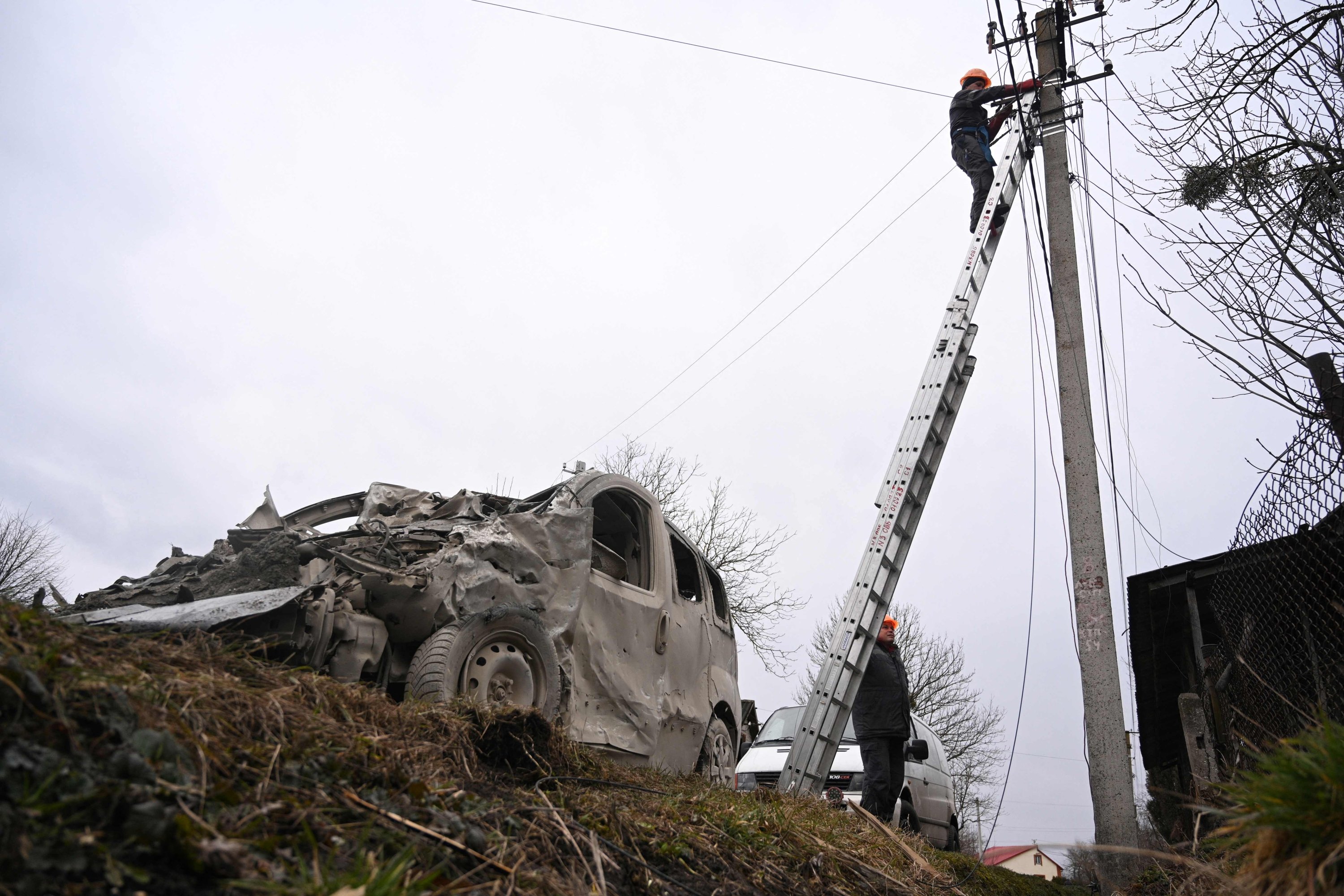 Seorang pekerja memperbaiki saluran listrik setelah serangan Rusia di desa Velyka Vilshanytsia, Lviv, Ukraina, 9 Maret 2023. (Foto AFP)
