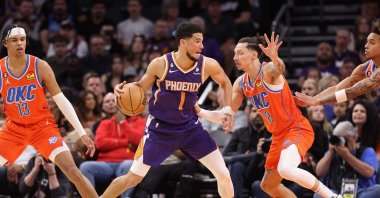 Phoenix Suns' Devin Booker (C) handles the ball against Oklahoma City Thunder's Lindy Waters III (R) during the first half of the NBA game at Footprint Center, Phoenix, Arizona, US., March 08, 2023. (AFP Photo)