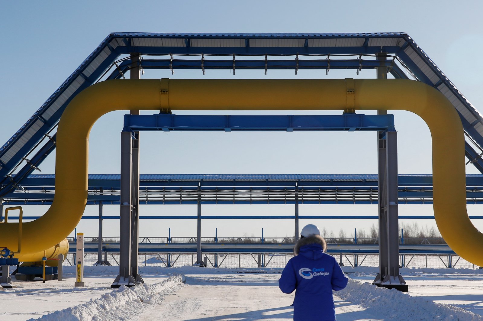 An employee in branded jacket walks past a part of Gazprom&#039;s Power Of Siberia gas pipeline at the Atamanskaya compressor station outside the far eastern town of Svobodny, in Amur region, Russia, Nov. 29, 2019. (Reuters photo)