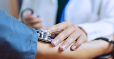 Doctor is checking patient with stethoscope and measuring blood pressure. (Shutterstock Photo)