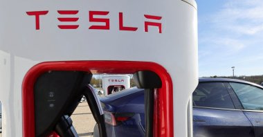 A driver recharges the battery of his Tesla car, at a Tesla Super Charging station, in a petrol station on the highway in Chateauvillain, France, February 20, 2023. (Reuters photo)