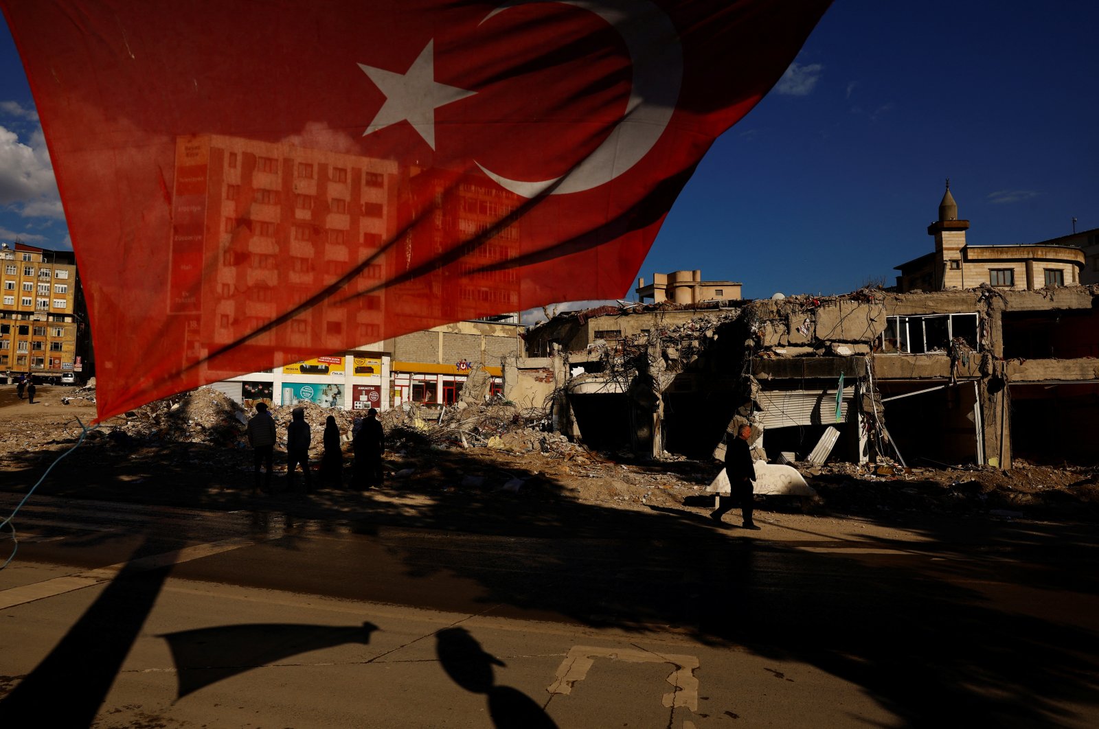 A Turkish flag flies next to damaged buildings in the aftermath of the deadly earthquakes in Kahramanmaraş, Türkiye, March 9, 2023. (Reuters Photo)