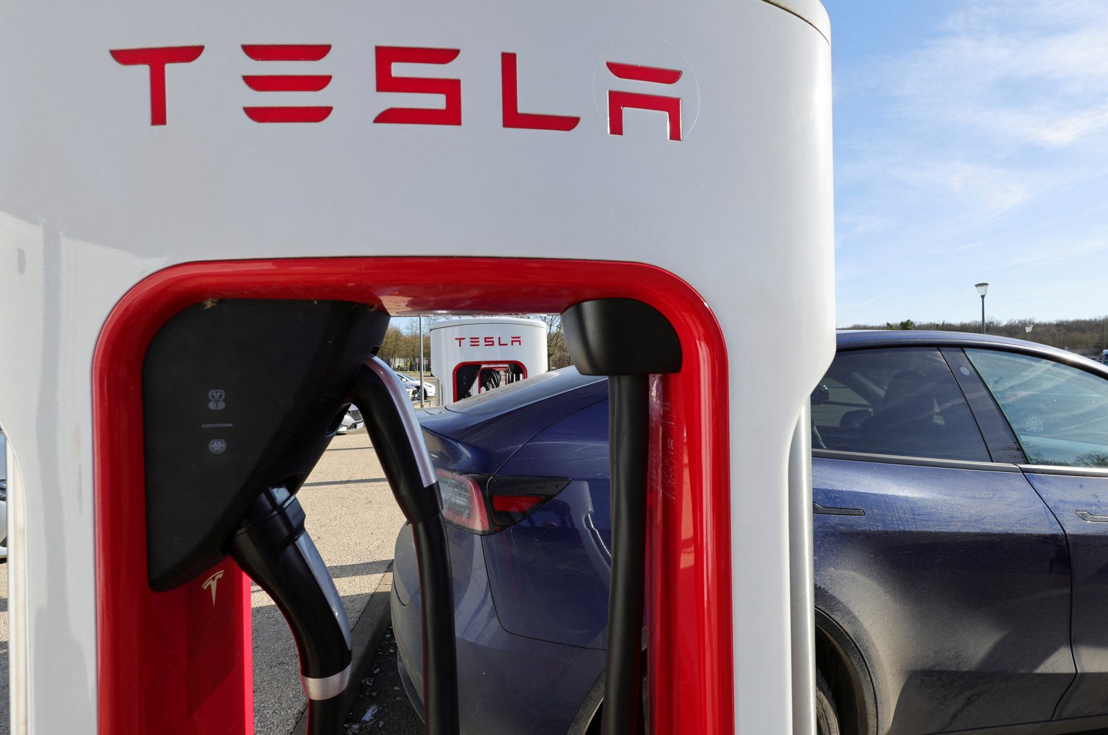 A driver recharges the battery of his Tesla car, at a Tesla Super Charging station, in a petrol station on the highway in Chateauvillain, France, February 20, 2023. (Reuters photo)
