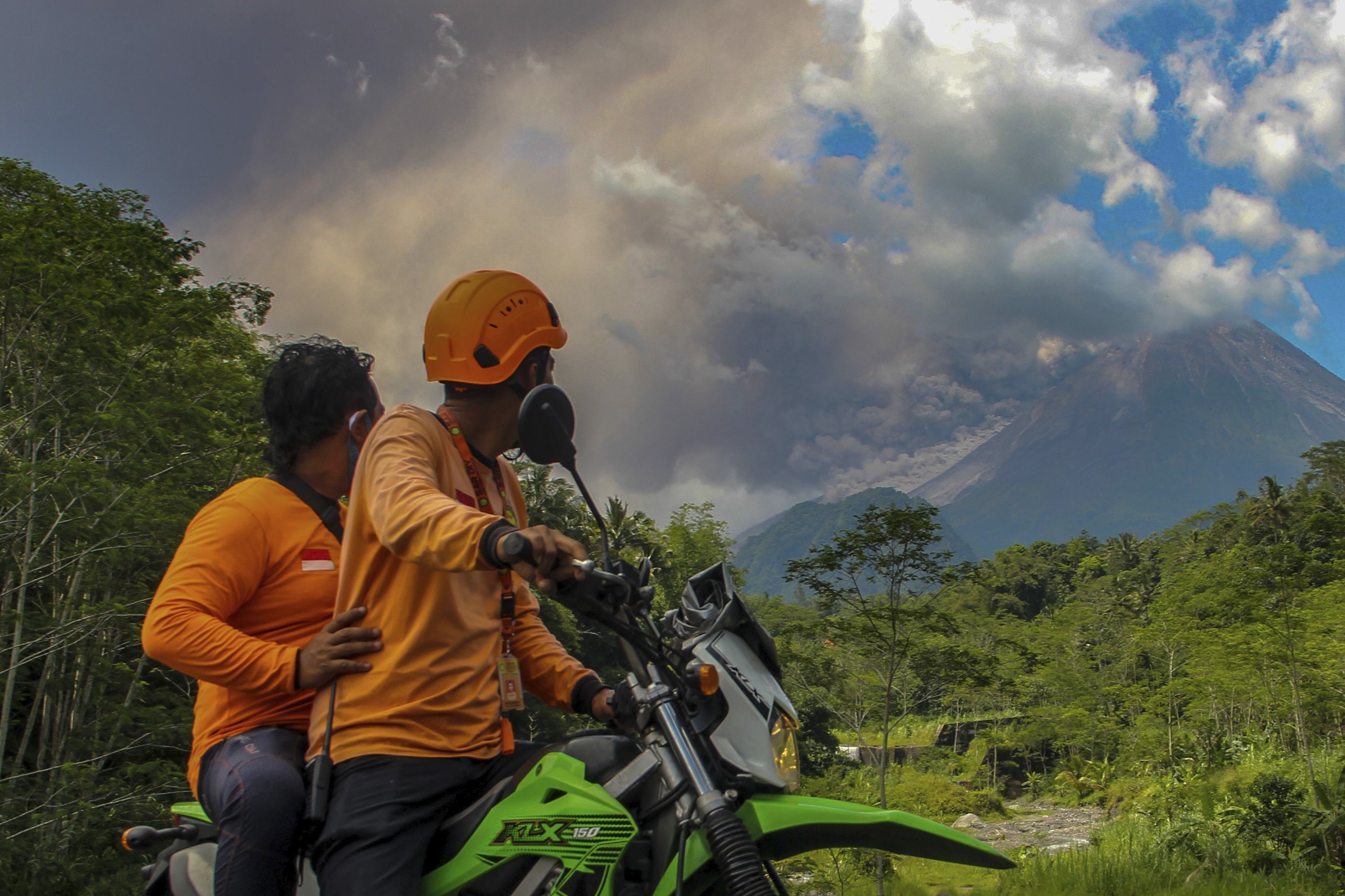 Pria menyaksikan Gunung Merapi melepaskan material vulkanik saat meletus di Sleman, Indonesia, 11 Maret 2023. (Foto AP)