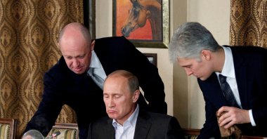 Yevgeny Prigozhin (left) assists Russian Prime Minister Vladimir Putin during a dinner with foreign scholars and journalists at the restaurant Cheval Blanc on the premises of an equestrian complex outside Moscow Nov. 11, 2011. (Reuters File Photo)